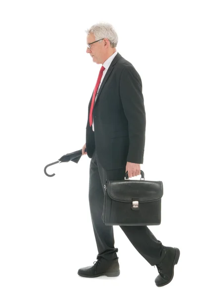Senior affärsman promenader med paraply och väska — Stockfoto