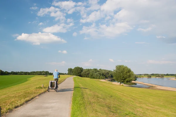 Man on bike near river — Stock Photo, Image