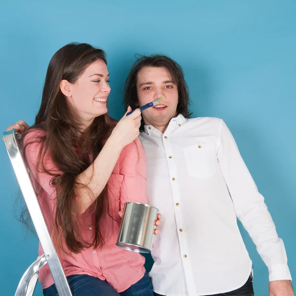 Jovem casal divertido enquanto pintura casa — Fotografia de Stock