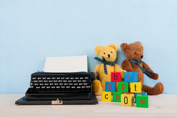 Máquina de escrever vintage com brinquedos antigos — Fotografia de Stock