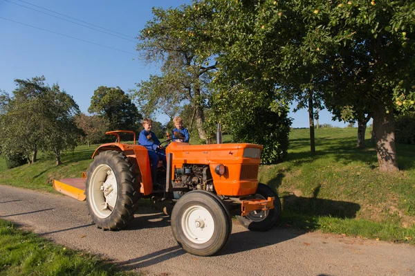 Farm chłopcy na ciągnik — Zdjęcie stockowe