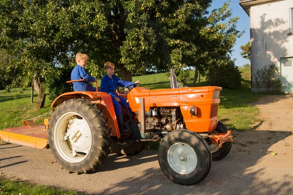 Chlapci farma s traktorem — Stock fotografie