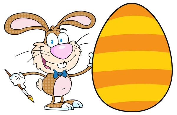 Happy bunny schilderen een easter egg — Stockvector