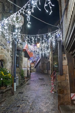 Mont Saint Michel 'de beyaz Noel ışıklarıyla aydınlatılan büyüleyici bir kaldırım taşı geçidi büyülü bir akşam atmosferi yaratıyor..