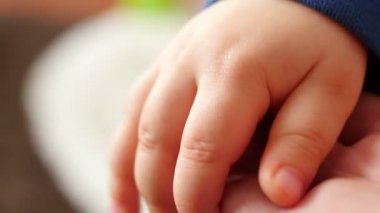 Bebeğin elini tutarak anne