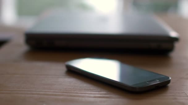 Laptop en mobiele telefoon op tafel — Stockvideo