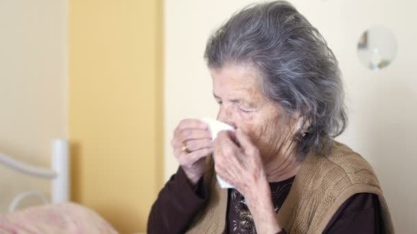 Unhealthy old woman blowing nose — Stock Video
