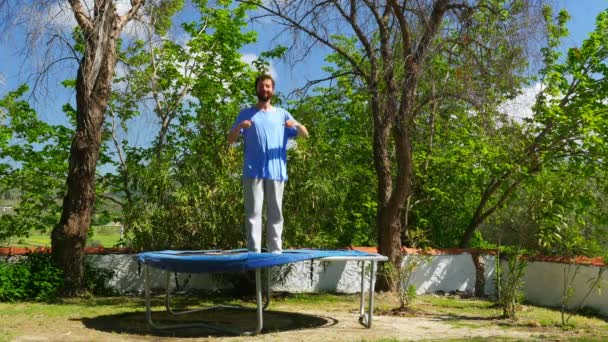 Gelukkig man springen op de trampoline — Stockvideo