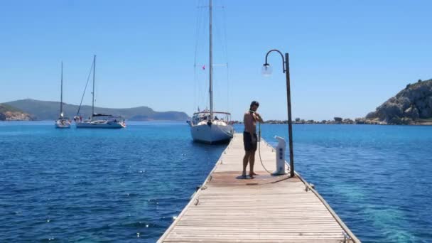 Man douchen op houten pier — Stockvideo