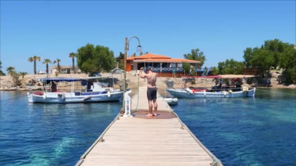 Hombre duchándose en muelle de madera — Vídeos de Stock