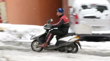 Karlı sokağa at binme scooter kurye