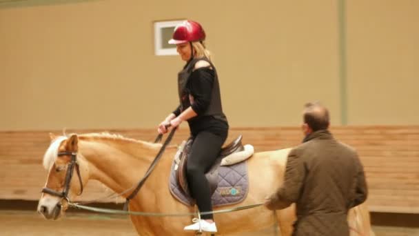 Mujer aprendiendo montar a caballo — Vídeos de Stock