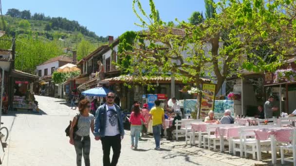 Turistas andando na rua da aldeia — Vídeo de Stock