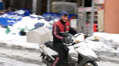 Karlı sokağa at binme scooter kurye