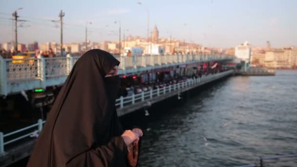 Mulher vestida com chador está comendo simit — Vídeo de Stock