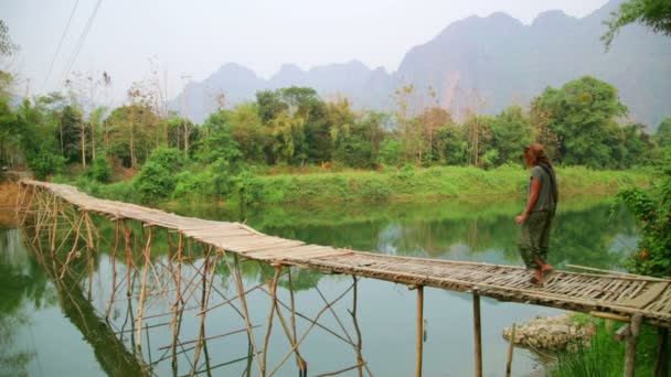 Tourist girl walking on bamboo bridge — Stock Video