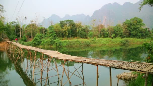 Pasando el puente de bambú en moto — Vídeos de Stock