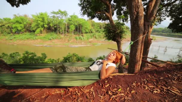 Туристка спит на гамаке — стоковое видео