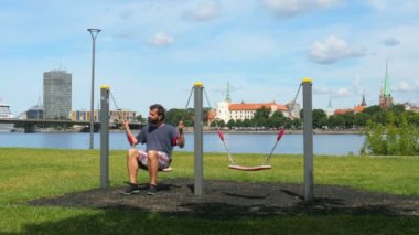 Salıncak Riga'da üzerinde sallanan adam