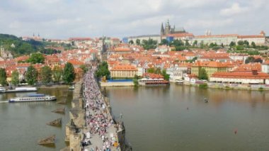 Prag'daki Charles köprüyü geçtikten insanlar