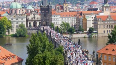 Prag'daki Charles köprüyü geçtikten insanlar