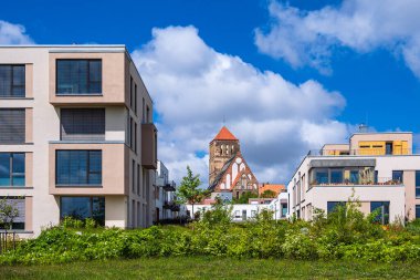 Almanya 'nın Rostock kentindeki modern binalar ve eski kilise.