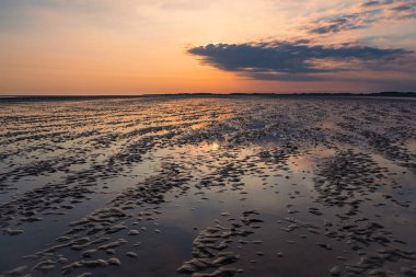 Almanya 'nın Amrum adasında gün doğumuyla çamurlu bir düzlük..