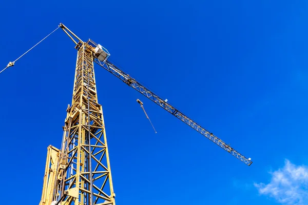 Yellow crane on a construction site with blue sky — Stock Photo, Image