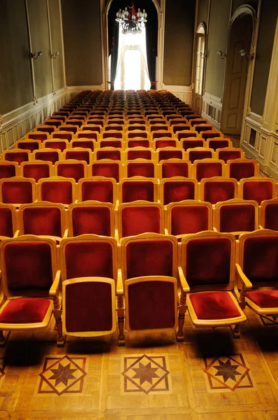 Конференц-зал з рядами червоних крісел — стокове фото