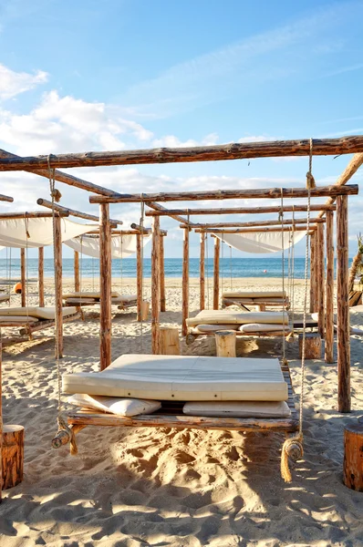 Sand suny beach with suspended beds — Stock Photo, Image