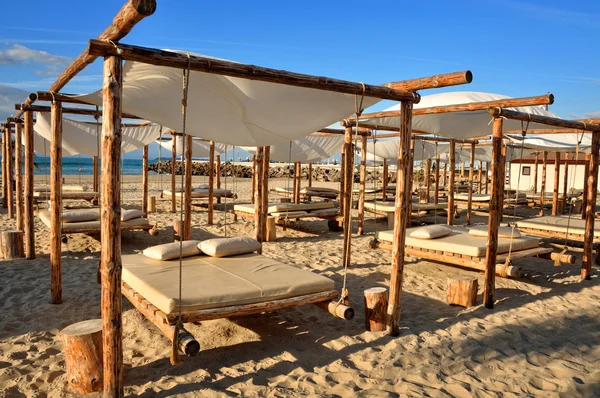 Sand suny beach with suspended beds — Stock Photo, Image