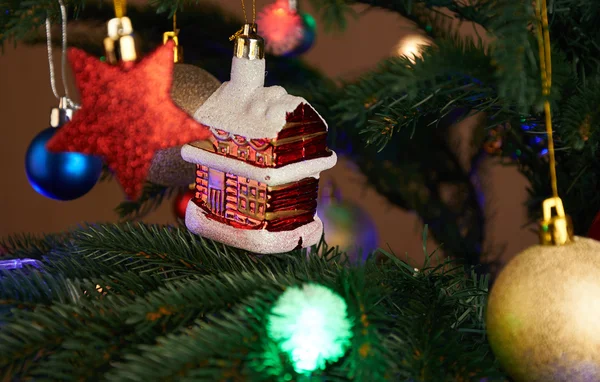 Maison, boules, étoiles et guirlande d'éclairage sur l'arbre de Noël — Photo