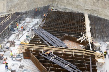 MILAN, ITALY - 25 Mart 2019: Porta Nuova 'daki büyük bir yeraltı kazısında yeni bir kompleksin temelleri üzerinde çalışan işçiler