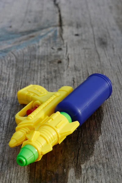 Pistola amarilla Squirt sobre fondo de madera — Foto de Stock