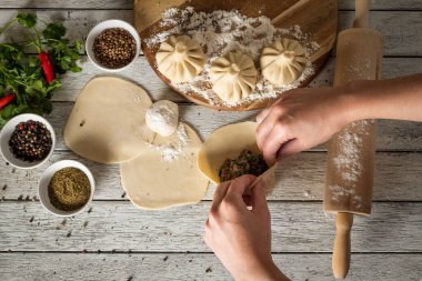 Close up to Caucasian khinkali dumplings dish served on plate. Background with ingredients and scattered spices