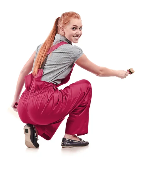 Young happy woman in red jumpsuit with painting tools — Stock Photo, Image