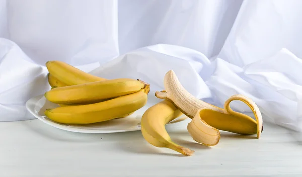 Rijpe bananen op witte tafel — Stockfoto