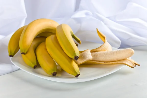 Rijpe bananen op witte tafel — Stockfoto