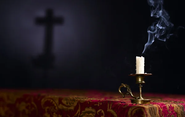 Candle on a dark background with the silhouette of the cross — Stock Photo, Image