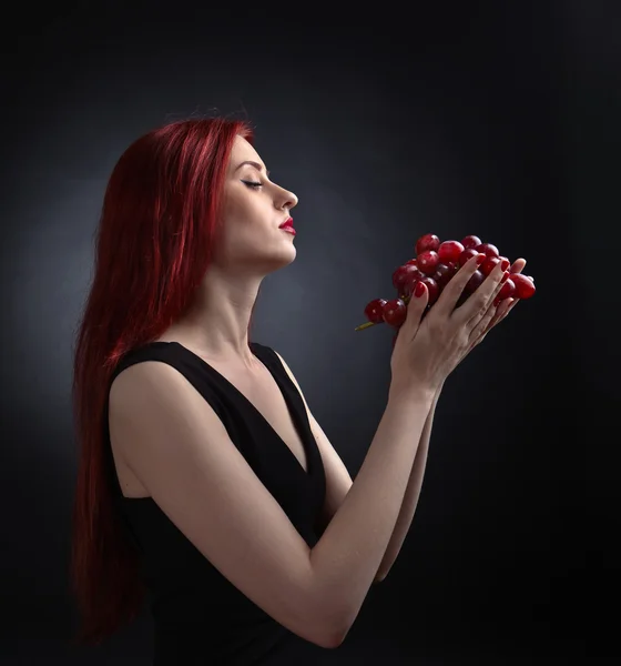 Bella donna dai capelli rossi con uva — Foto Stock