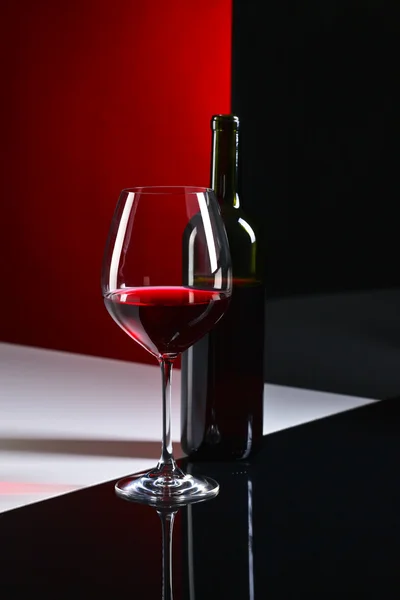 Bottiglia e bicchiere con vino rosso — Foto Stock