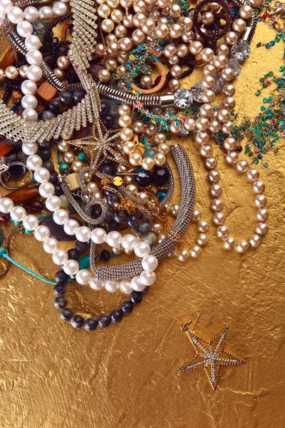 Various jewelry on a golden background. — Stock Photo, Image