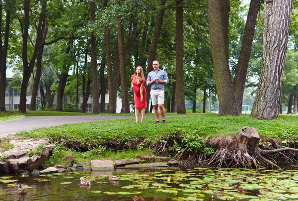 Zwangere vrouw met echtgenoot de eenden voeden — Stockfoto