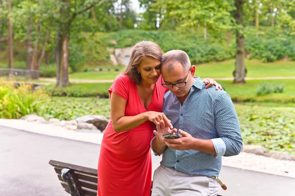 Mujer embarazada con su marido en el parque — Foto de Stock