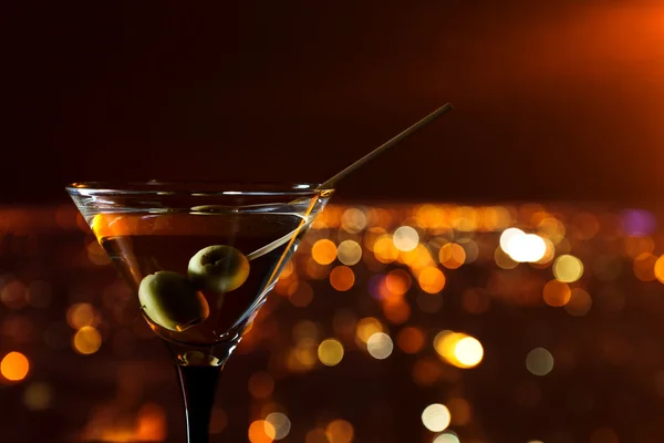 Martini aux olives sur fond de ville nocturne — Photo