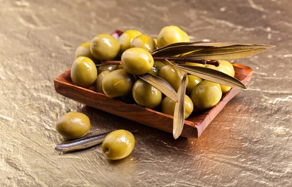 Green olives in wooden dish — Stock Photo, Image