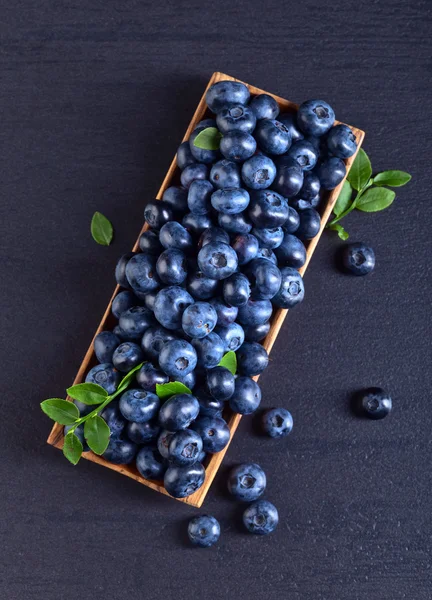 绿色的叶子，在木盘子里的蓝莓 — 图库照片