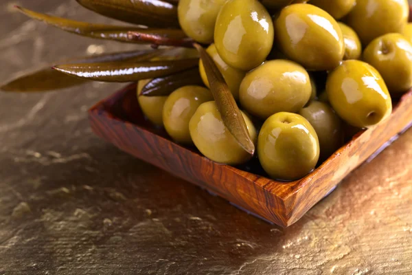 Green olives in wooden dish — Stock Photo, Image
