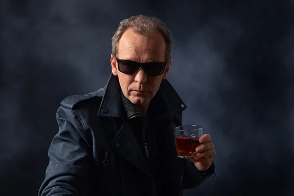 Man in sunglasses with glass of whiskey — Stock Photo, Image