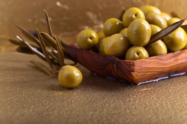 Zelené olivy v dřevěné misce — Stock fotografie